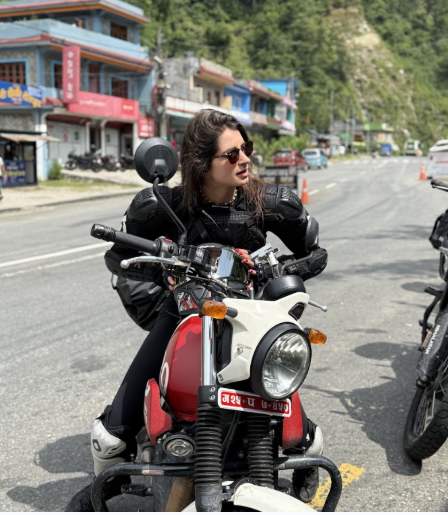 A Lady rider on himalayan scram 411 bike waiting someehere in the mountain highway around Kushma, Nepal Perfect for a short escape, this tour c